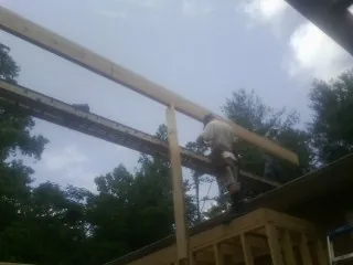 Carpenter setting a ridge beam over a new addition frame — Ice Dam Removal by Roofing Brothers in Marble Hill