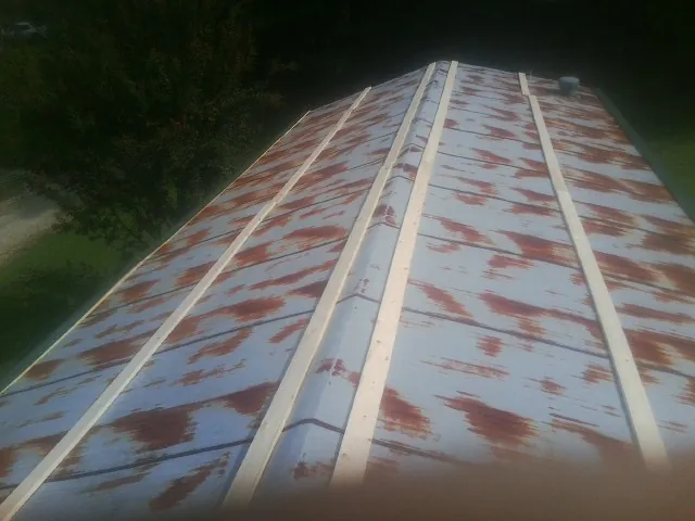Rusted metal roof panels with new wood purlins before replacement — Storm Damage Roof Repair in Marble Hill by Roofing Brothers