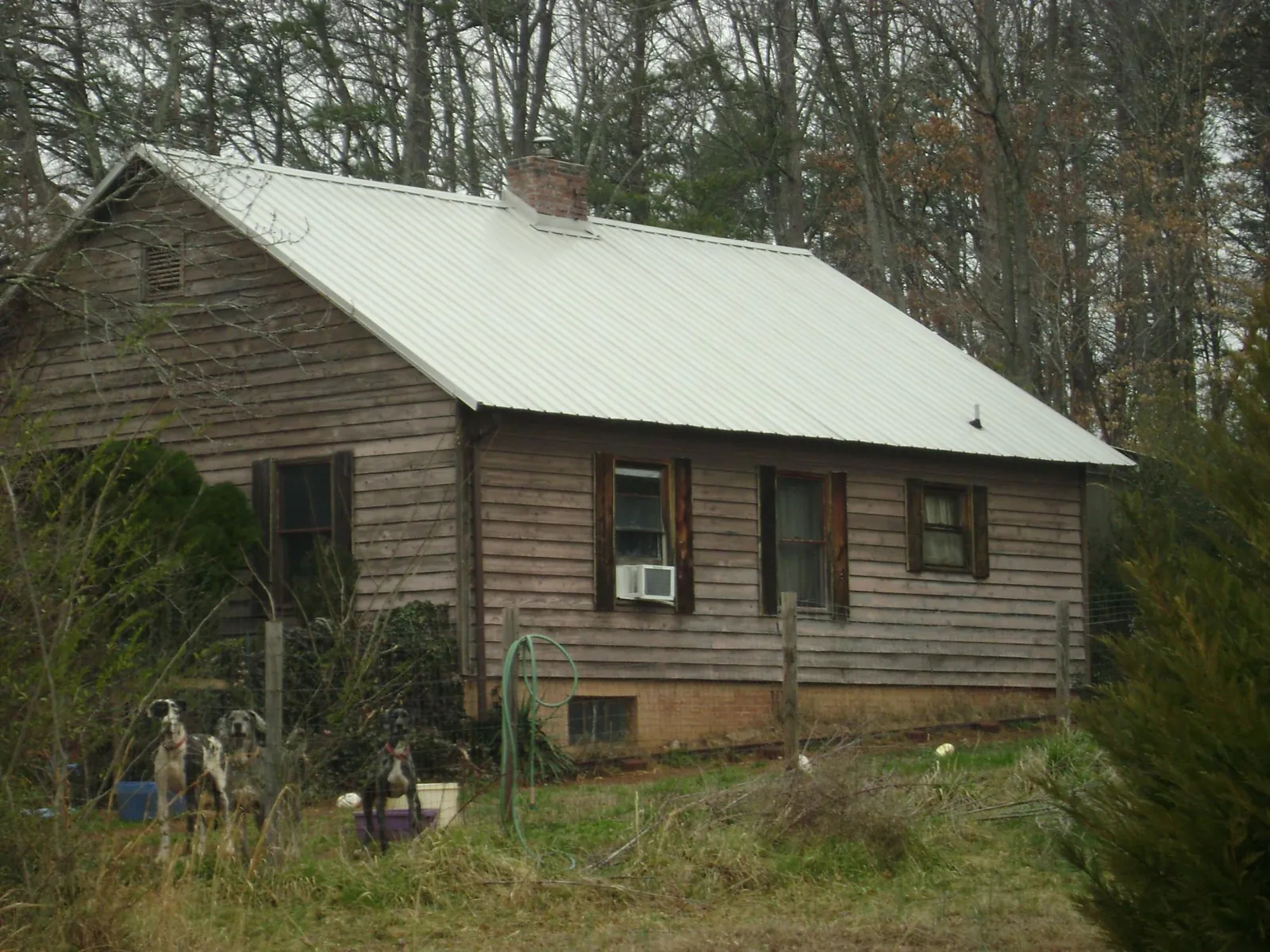 White metal roof on an old wood sided farmhouse, from a Metal Roof Installation job in Marble Hill
